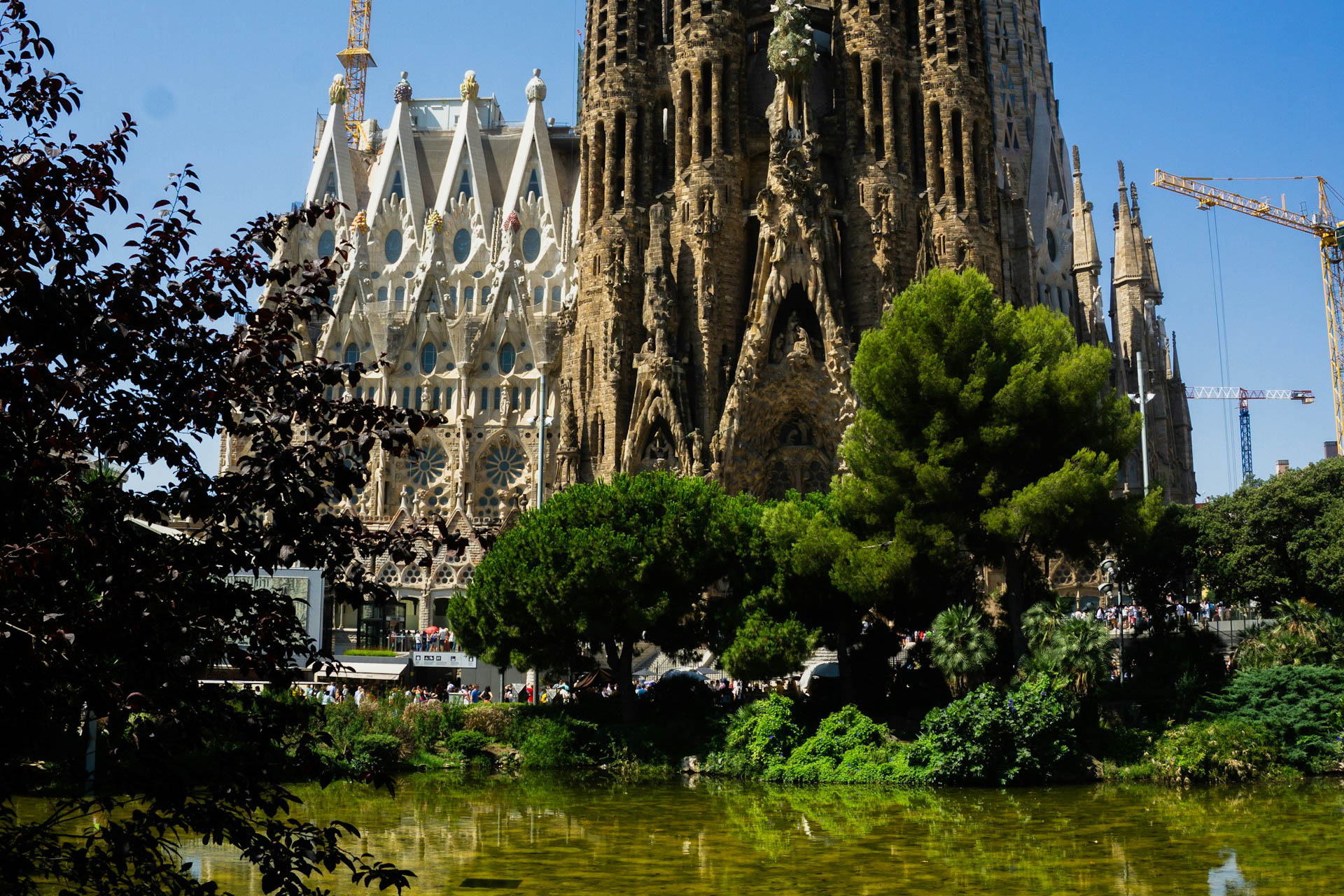 Die Kirche Sagrada Familia in Barcelona mit Baukränen im Hintergrund.