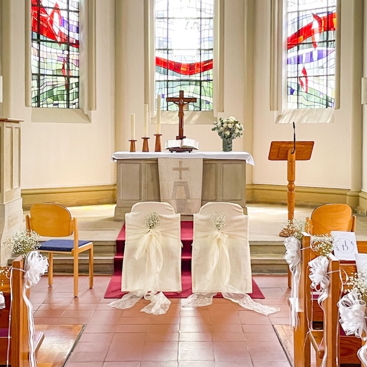 Zwei geschmückte Stühle vor einem Altar