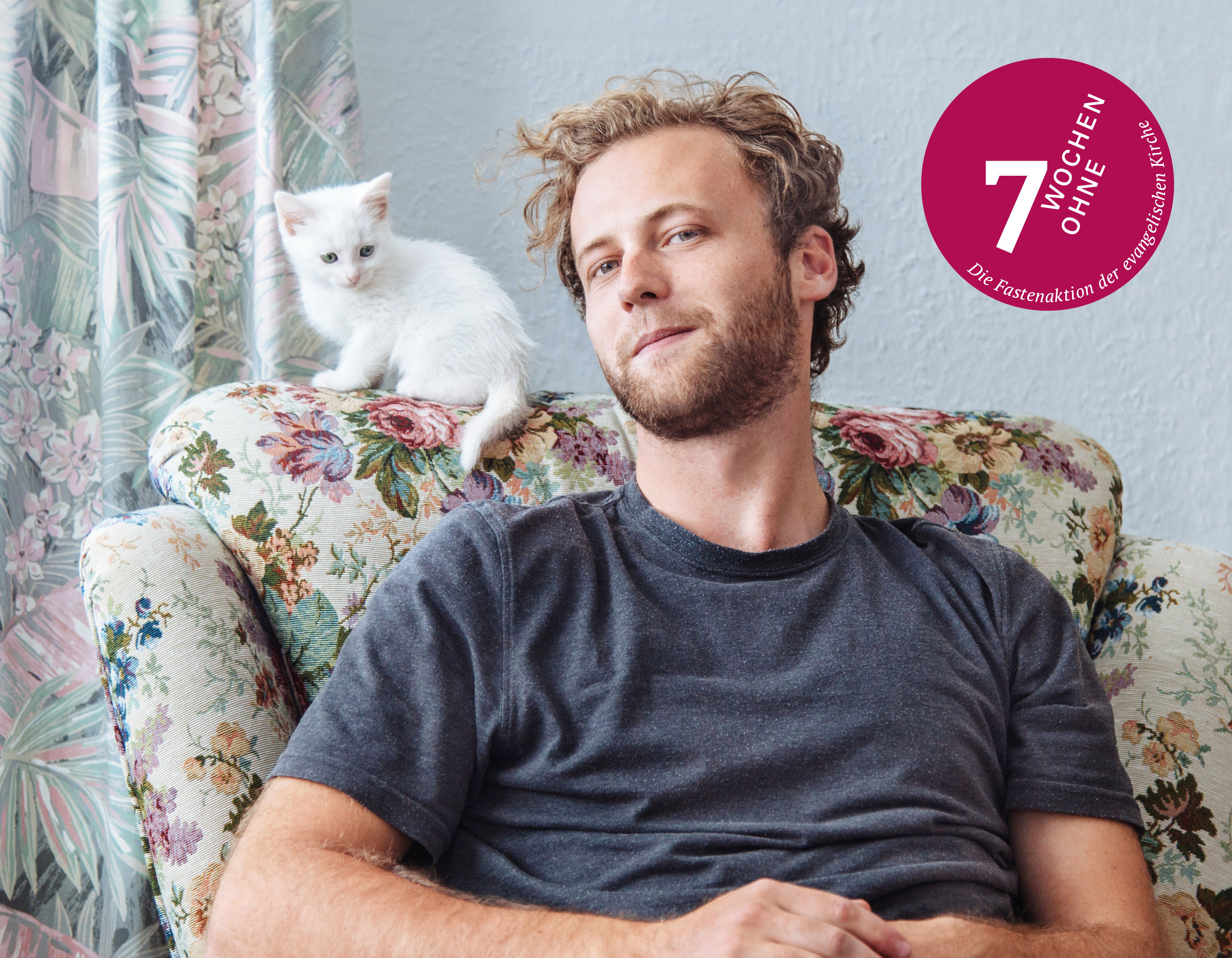 Ein Mann und eine Katze auf einem altmodischen Sessel